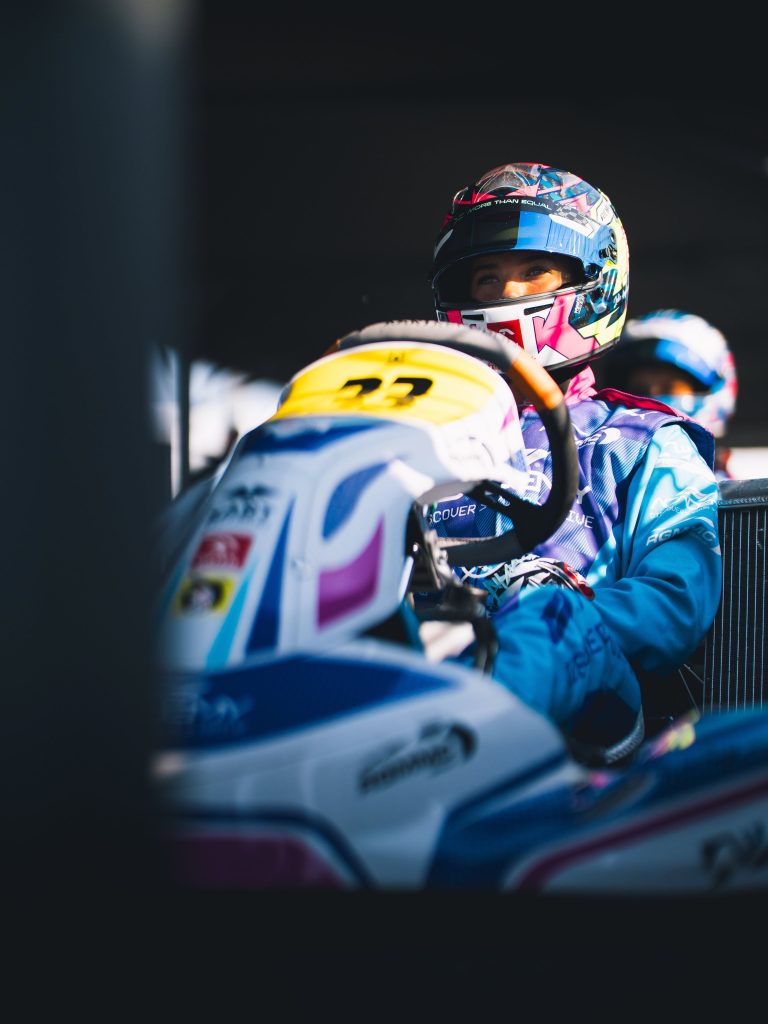 Primo piano di Julia Angelard al volante, livrea F1 Academy Discover Your Drive